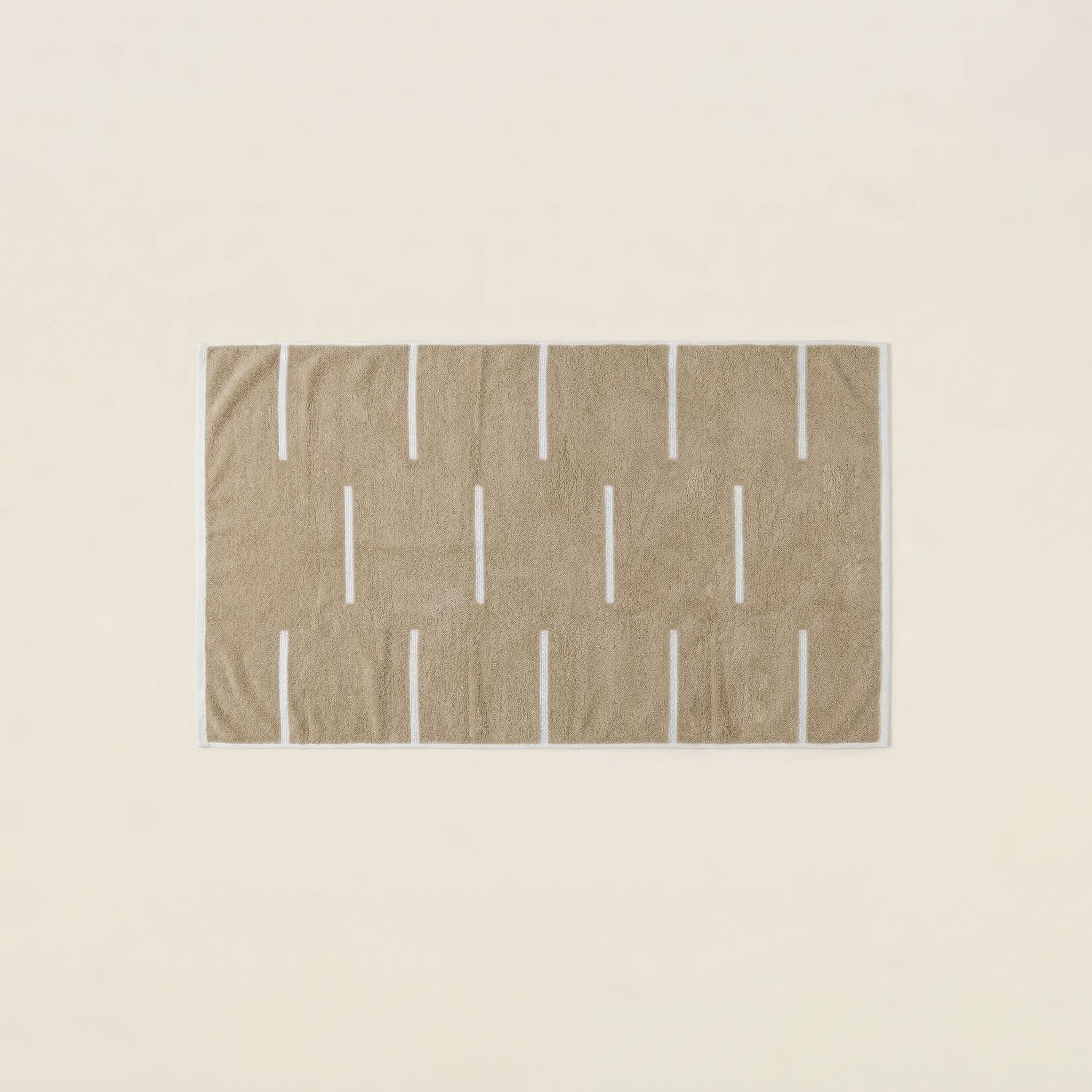 Sorrel Australian Cotton towel in warm sand beige with a plush texture, white geometric stripe pattern and finished border