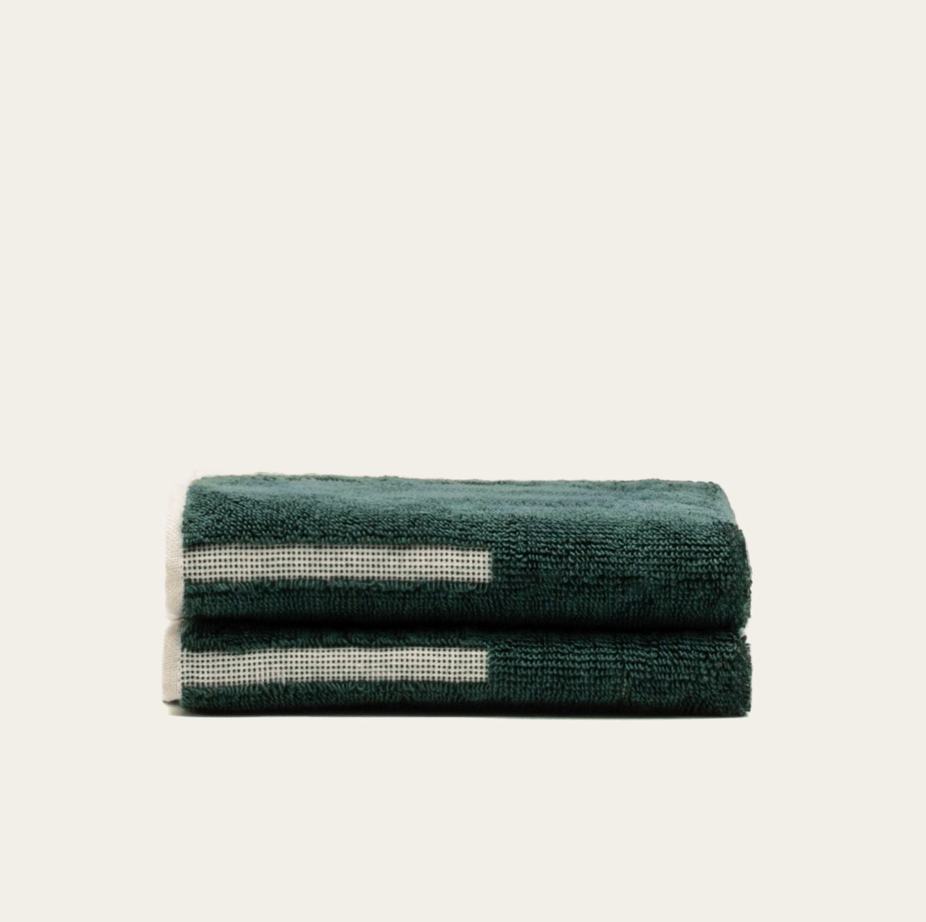 Sorrel Australian Cotton towels in deep teal plush fabric with cream geometric stripe accents and folded edges
