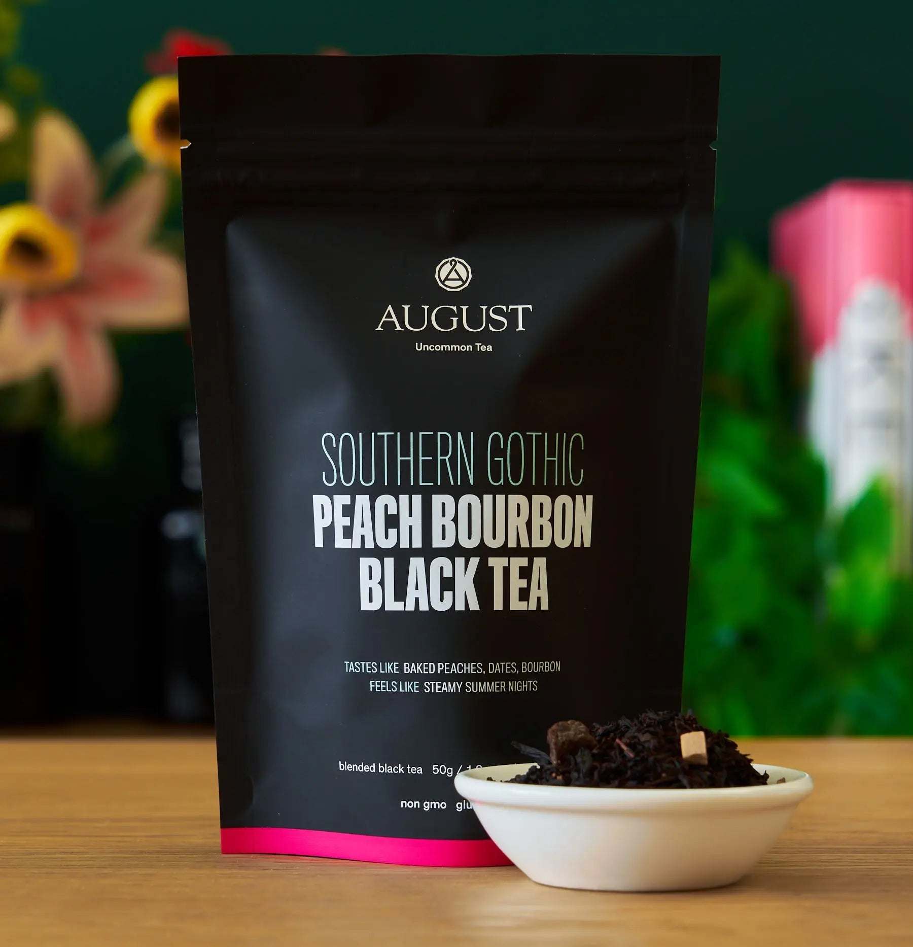 Southern Gothic - Peach Bourbon Black Tea in a black resealable pouch with bold white lettering and peach tea leaves beside it