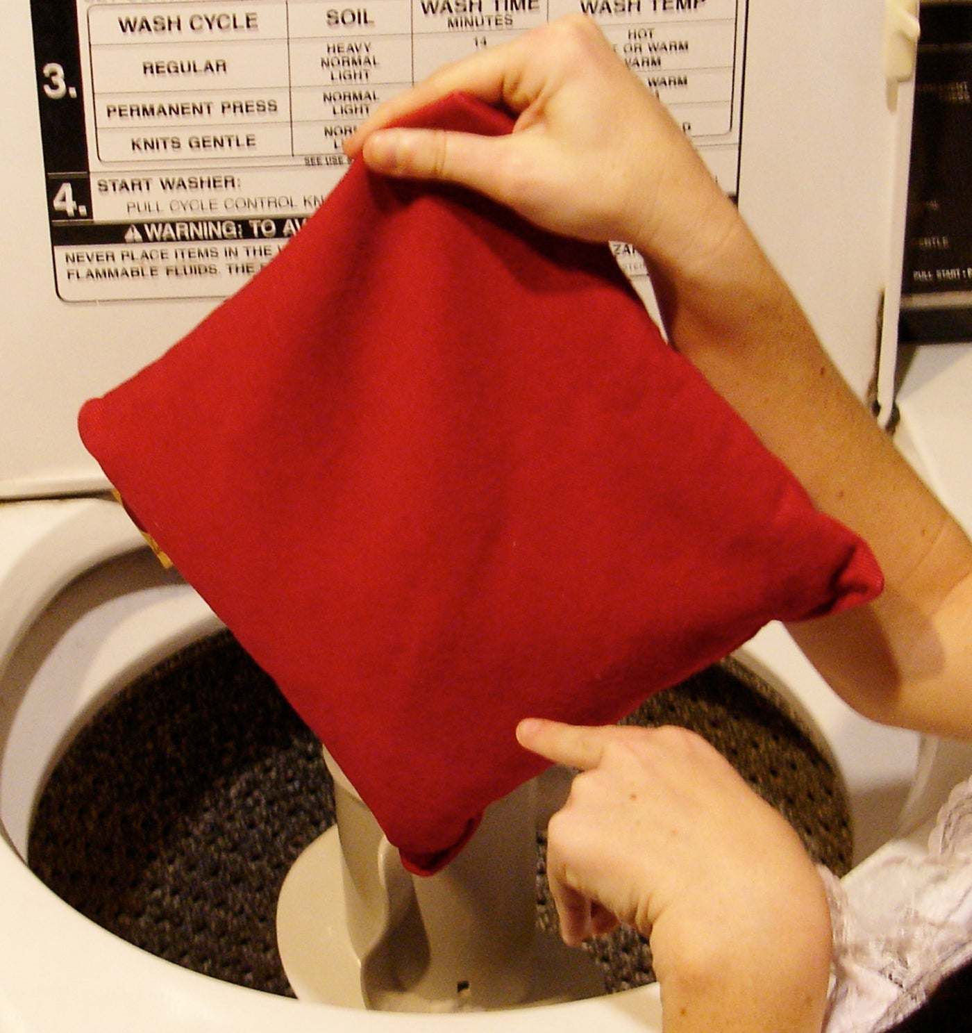 Square Pillow in Plush, a solid red square cushion with soft suede-like fabric and a simple stitched edge