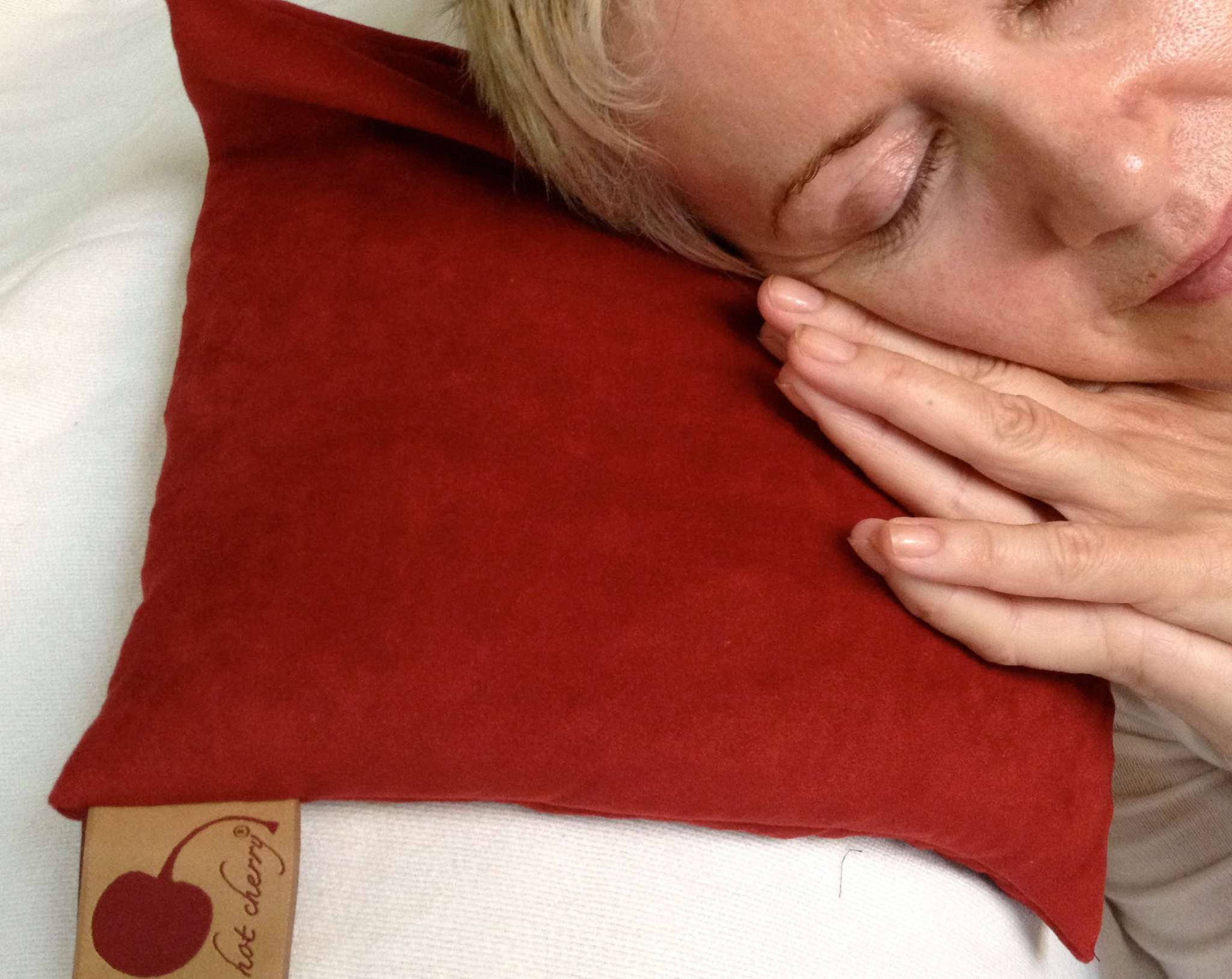 Square Pillow in Plush red ultra-suede with a soft, smooth surface and square shape, shown being cuddled