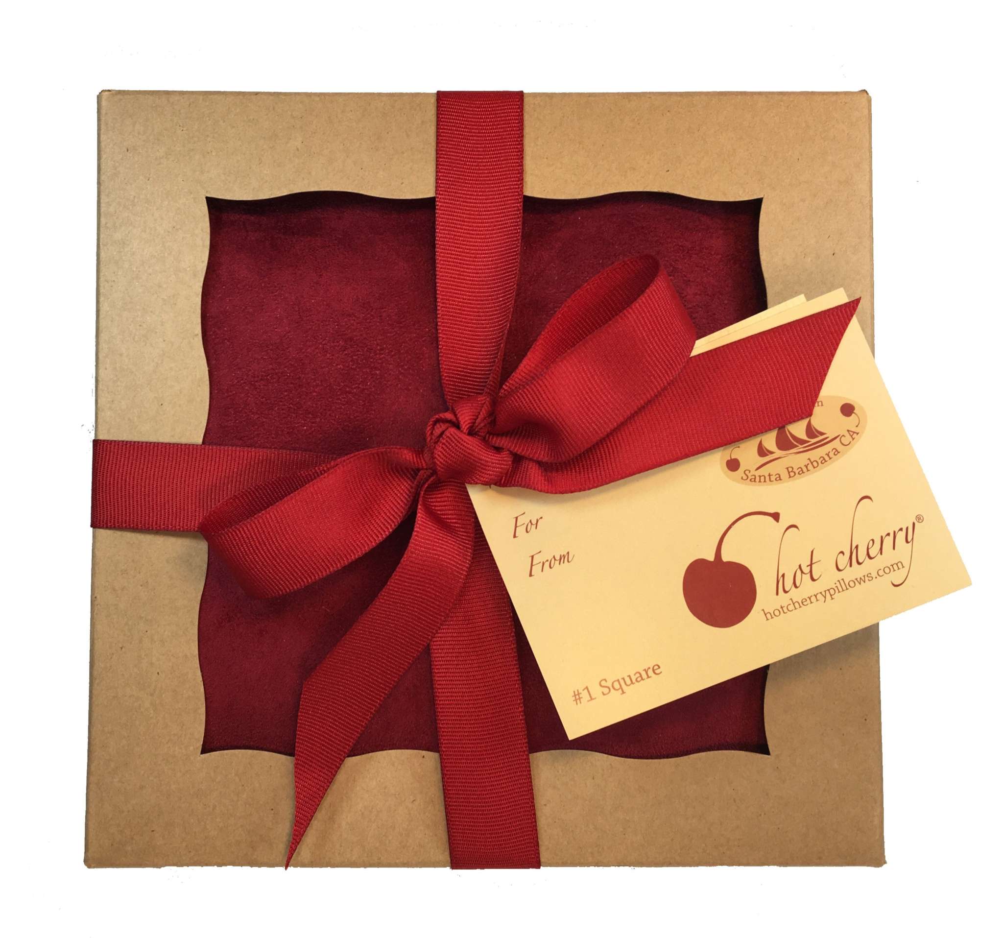 Square Pillow in Plush, rich red fabric with a soft velvety texture, packaged in a kraft box with ribbon and gift tag