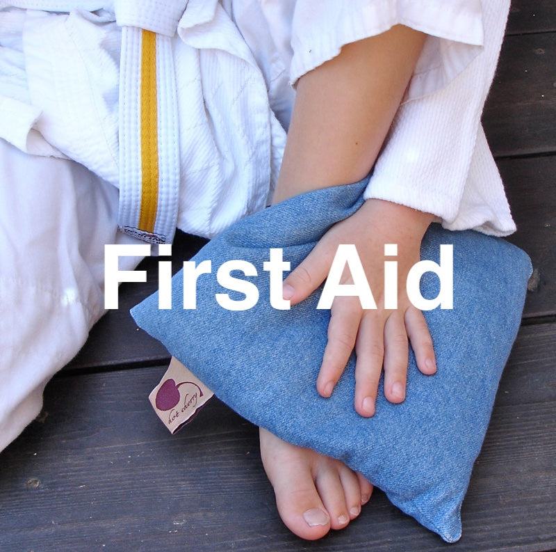 Summer Stack denim pillow in blue, shown as a soft square cushion held against a person's foot