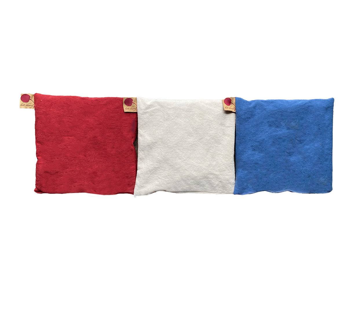 Summer Stack square denim pillows in red, natural white and blue, with soft fabric and small corner button tabs