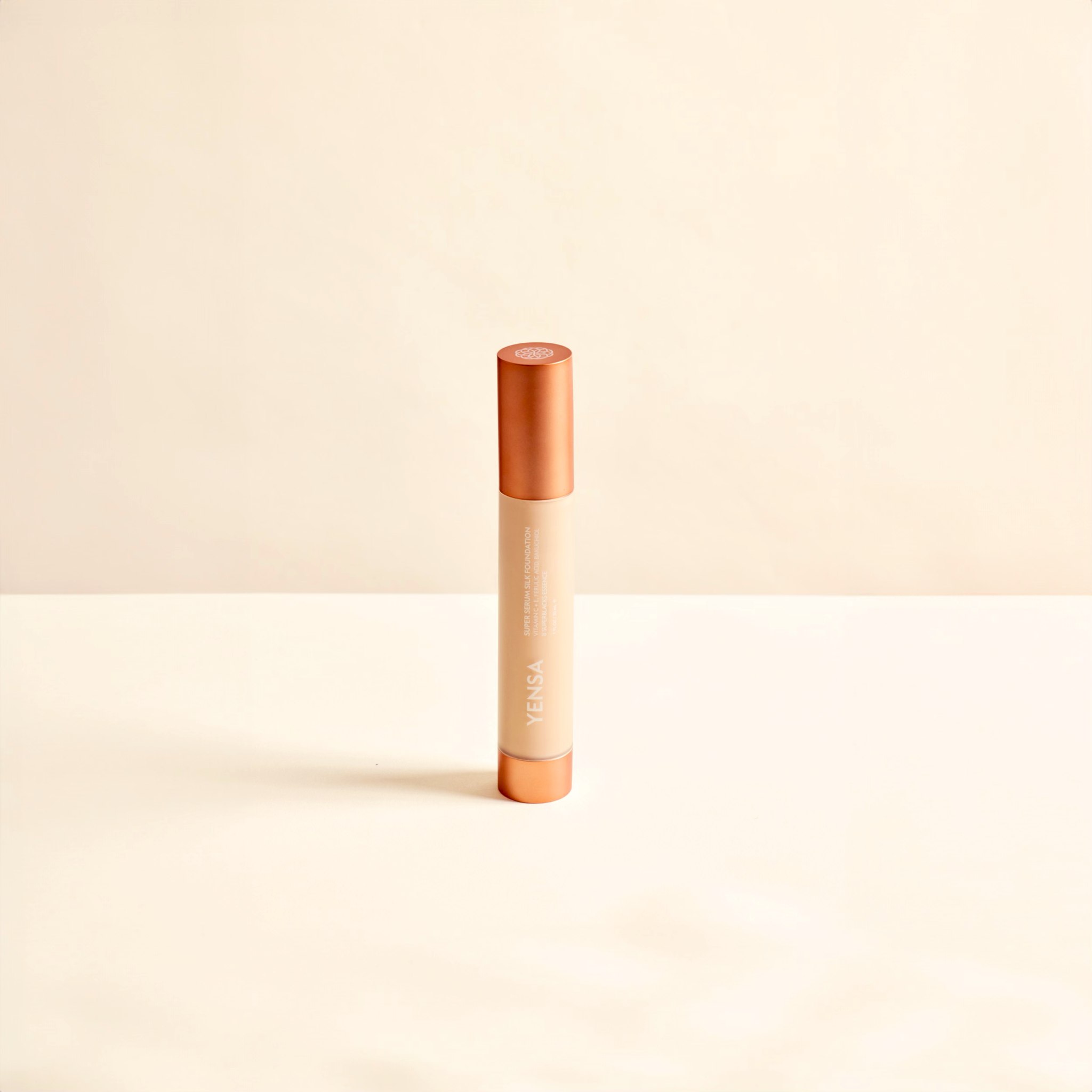Super Serum Silk foundation in a slim beige cylindrical tube with a copper-toned cap and vertical branding