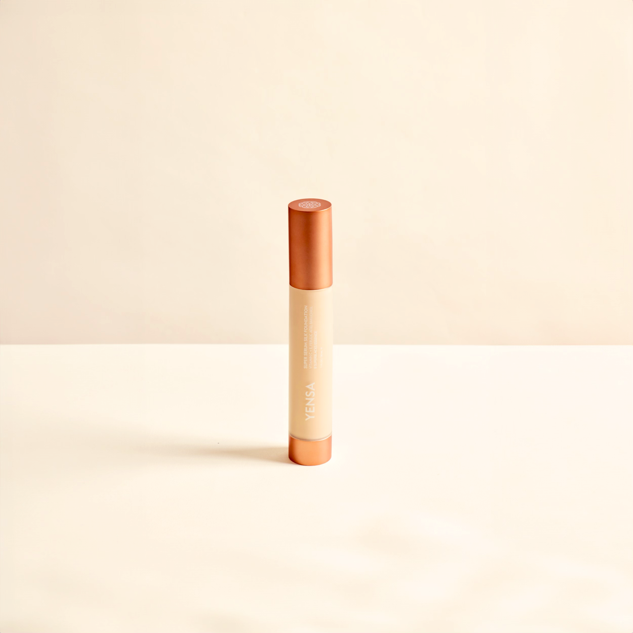 Super Serum Silk foundation in a slim pale beige tube with a copper cap and vertical white branding