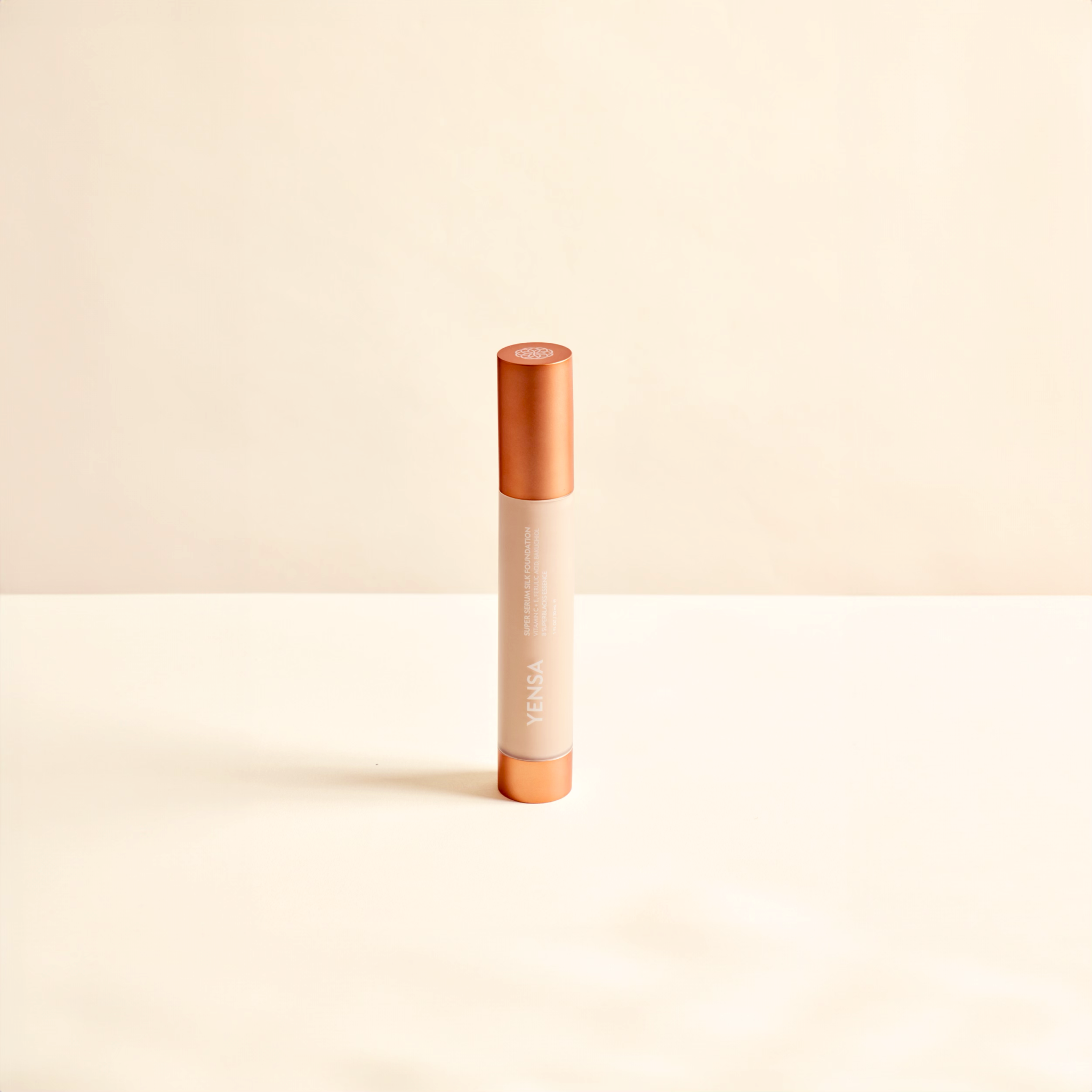 Super Serum Silk foundation in a slim beige tube with a warm copper cap and matching base, featuring vertical branding