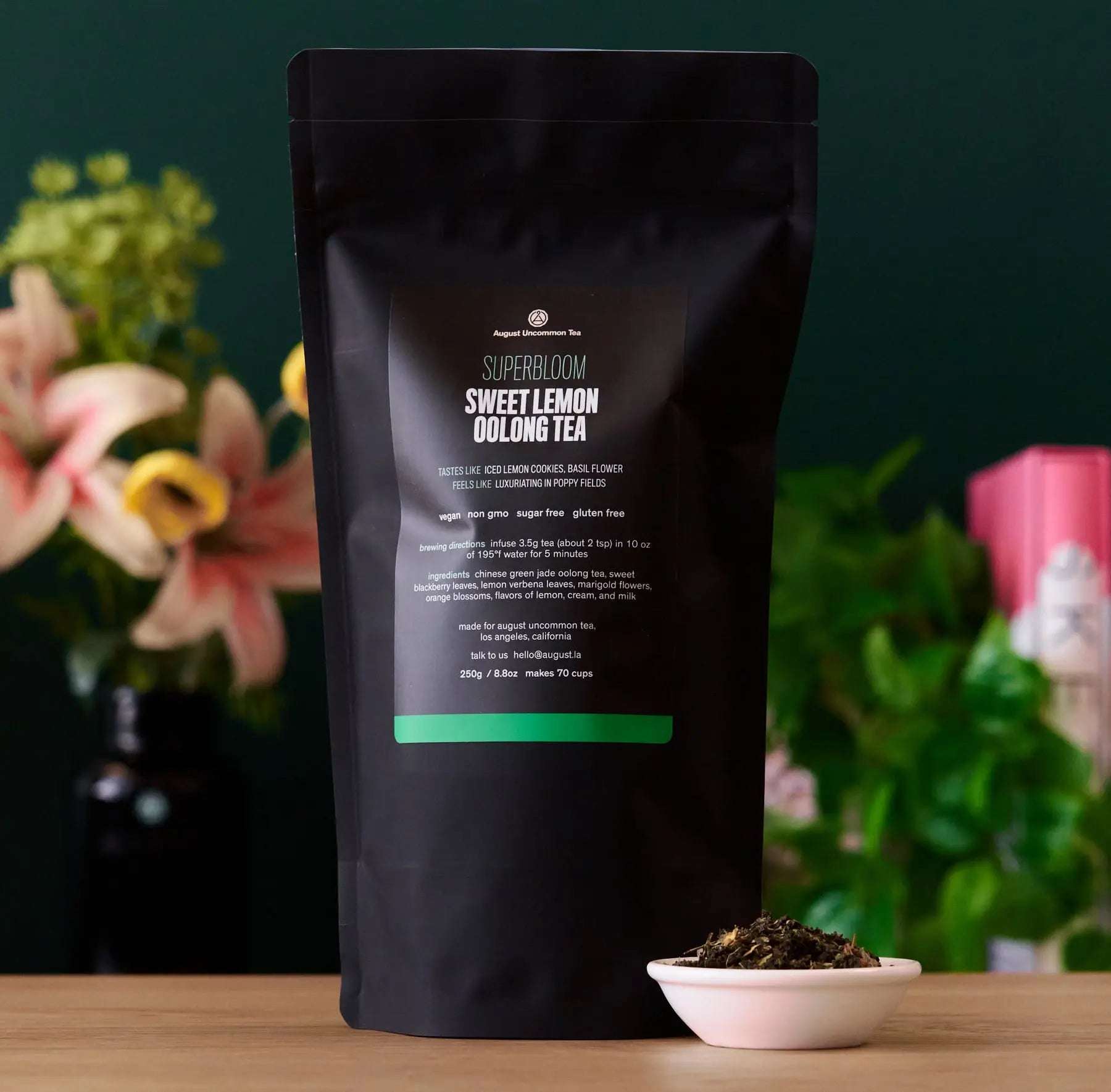 Superbloom - Sweet Lemon Oolong Green Tea in a matte black pouch with loose tea in a pink bowl