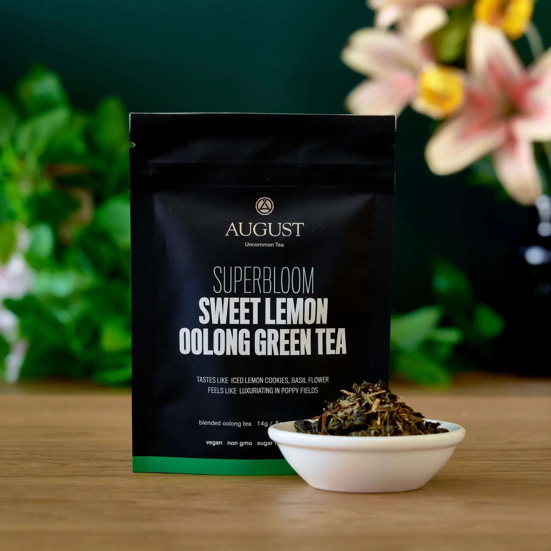 Superbloom - Sweet Lemon Oolong Green Tea black pouch with white lettering and loose-leaf tea in a ceramic bowl