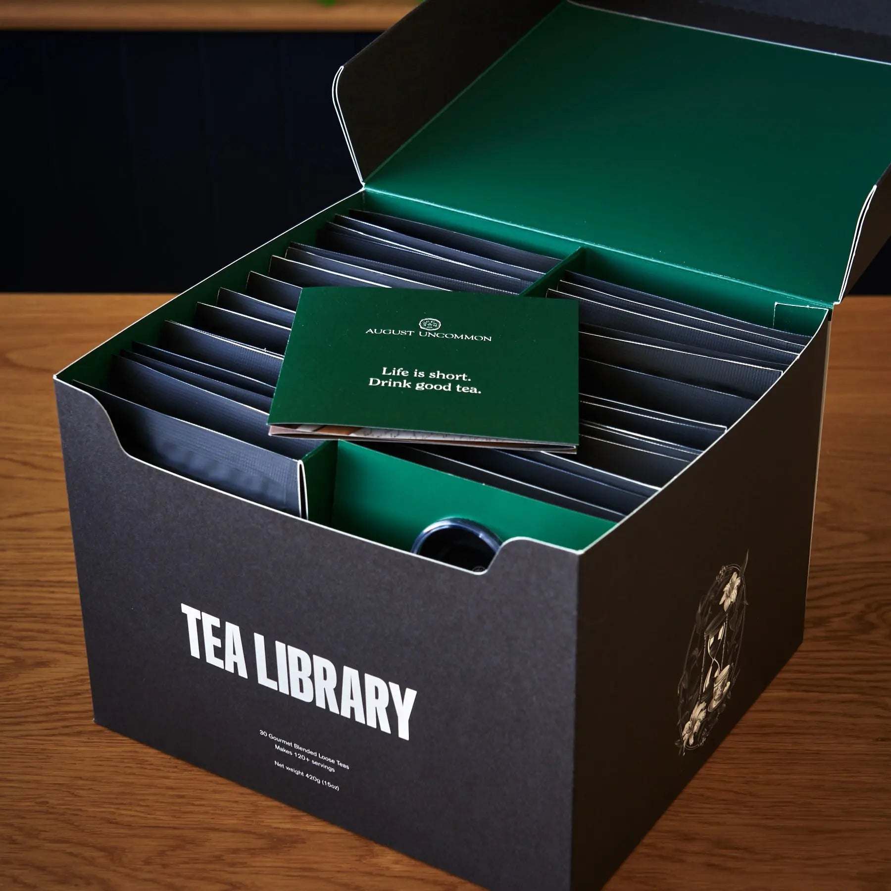 Tea Library - Deluxe sampler in a black and emerald green box, with divided tea packets and a matching card