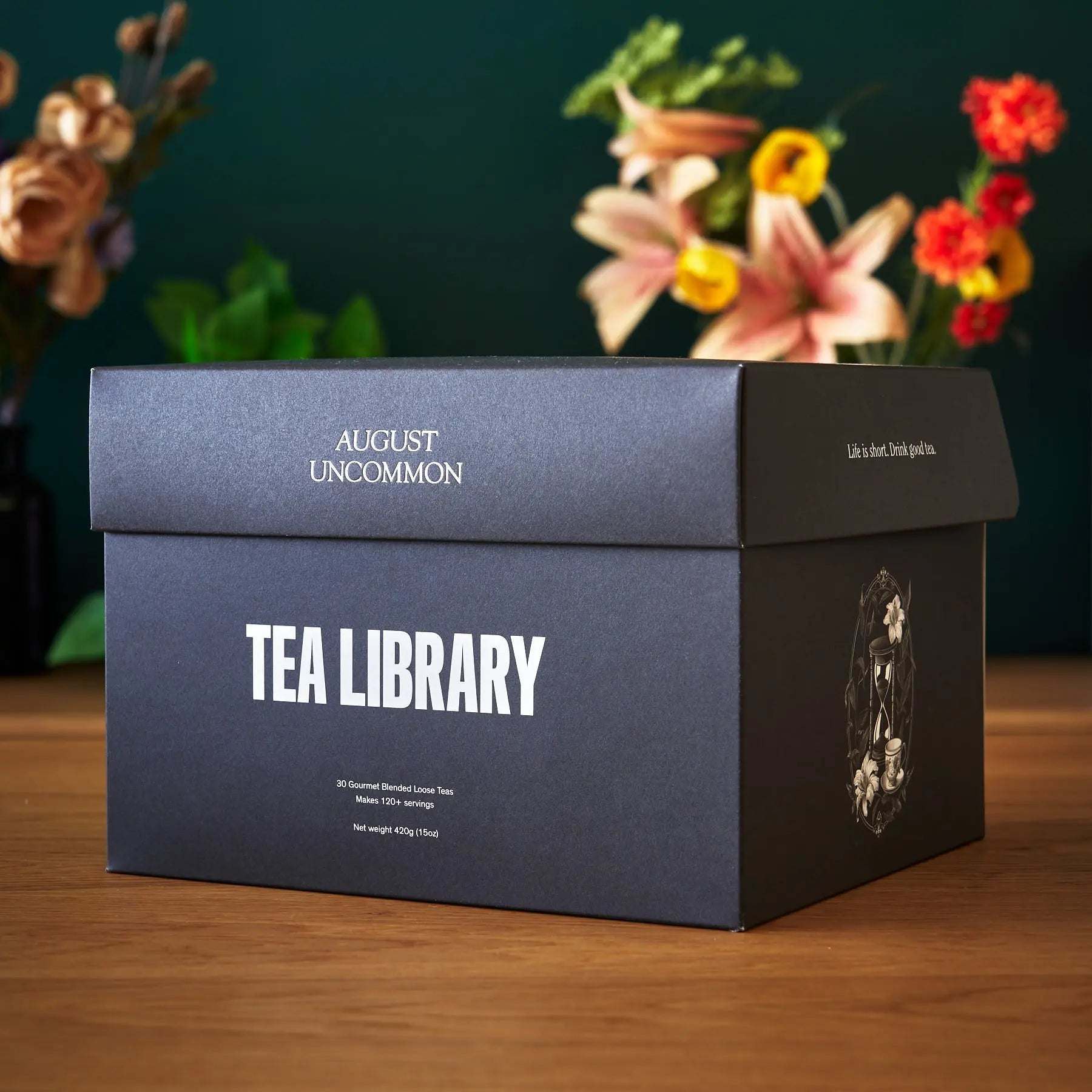 Tea Library - Deluxe sampler in a dark charcoal box with white lettering and ornate side illustration