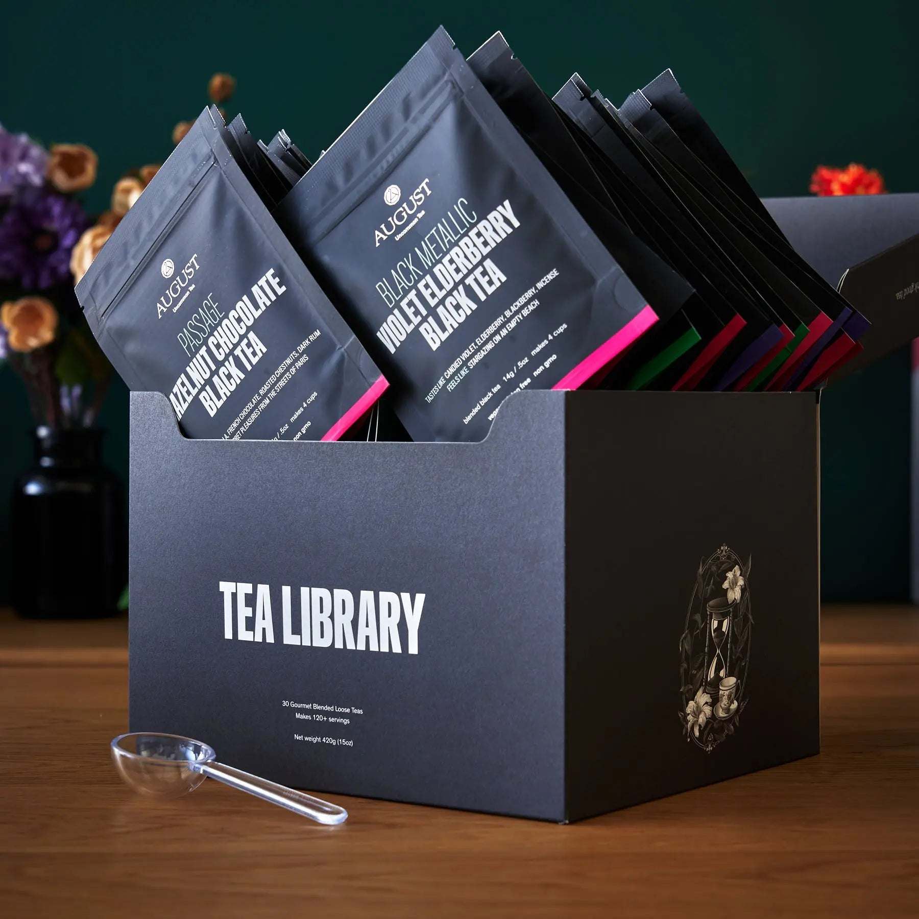 Tea Library - Deluxe tea sampler in a dark blue box with assorted black tea sachets and a clear tea scoop