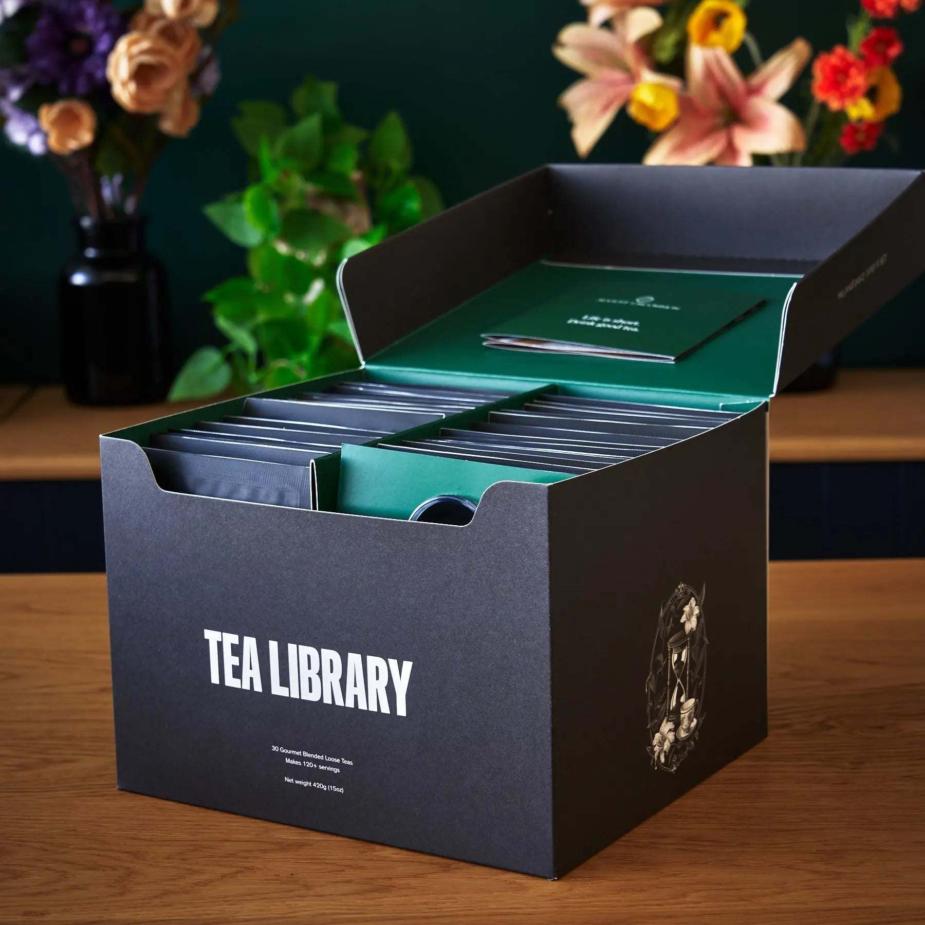 Tea Library - Deluxe tea sampler in a dark charcoal box with teal packets and a bold white label