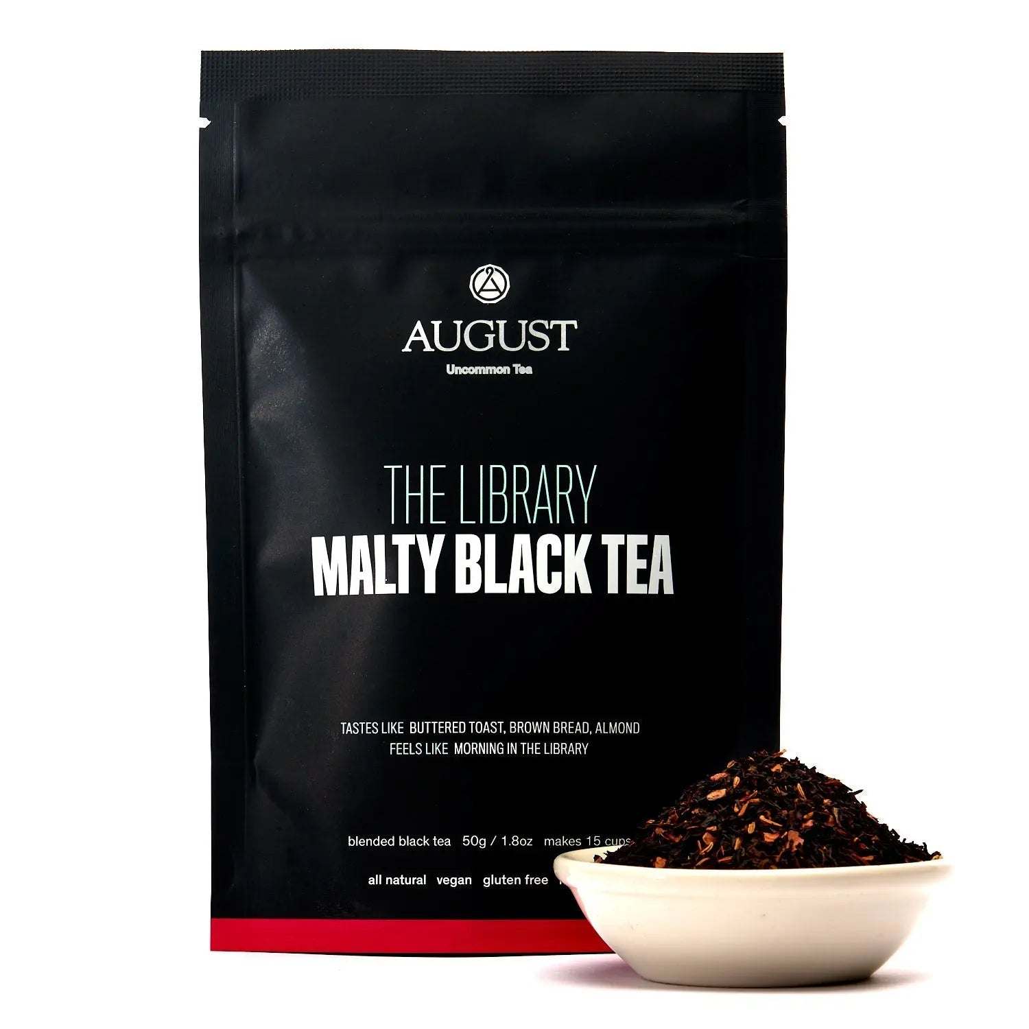 Black tea pouch in matte black packaging, with loose malty tea leaves displayed in a white bowl; The Library - Black Tea label