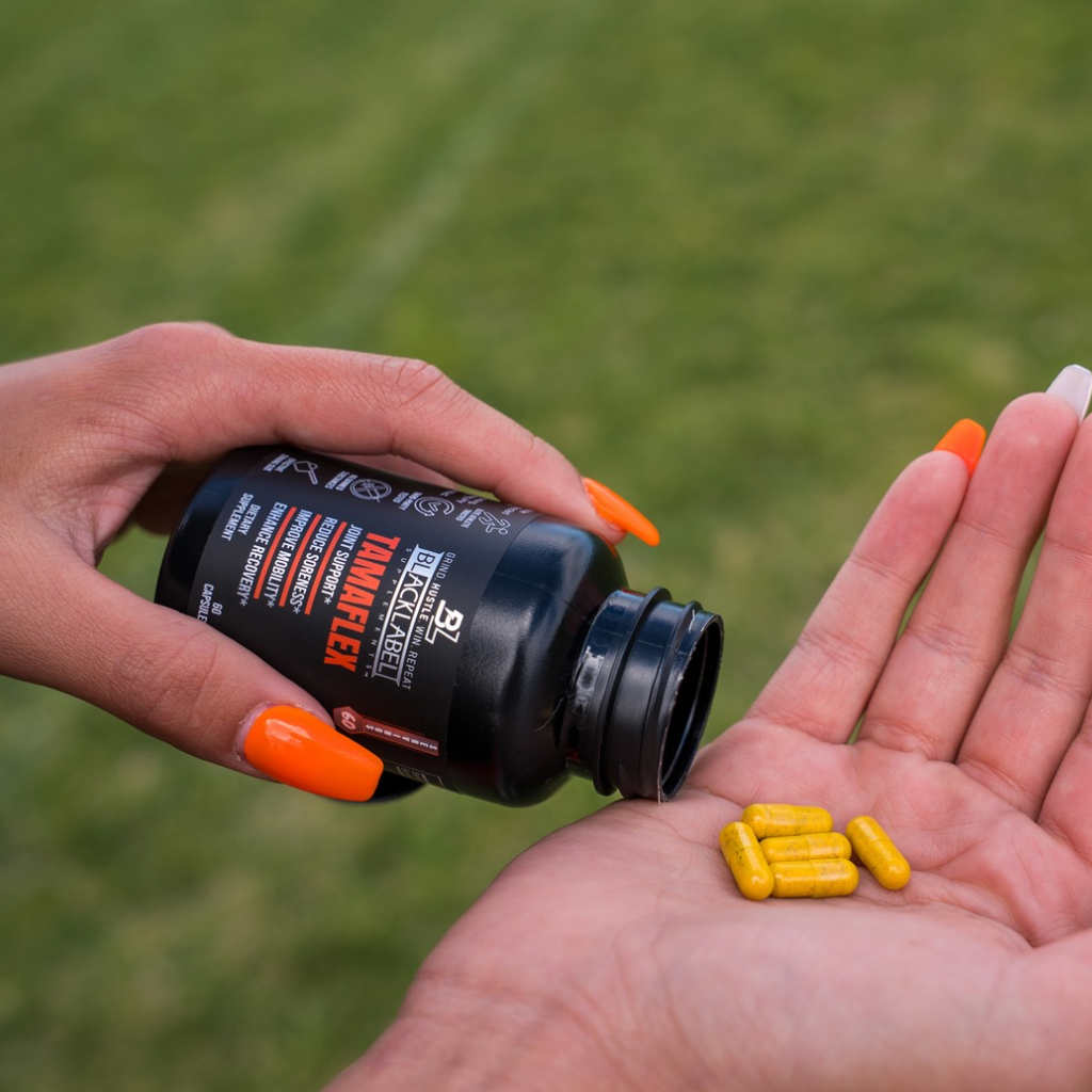 Joint support supplement bottle pouring yellow capsules onto a palm during Training hard routines