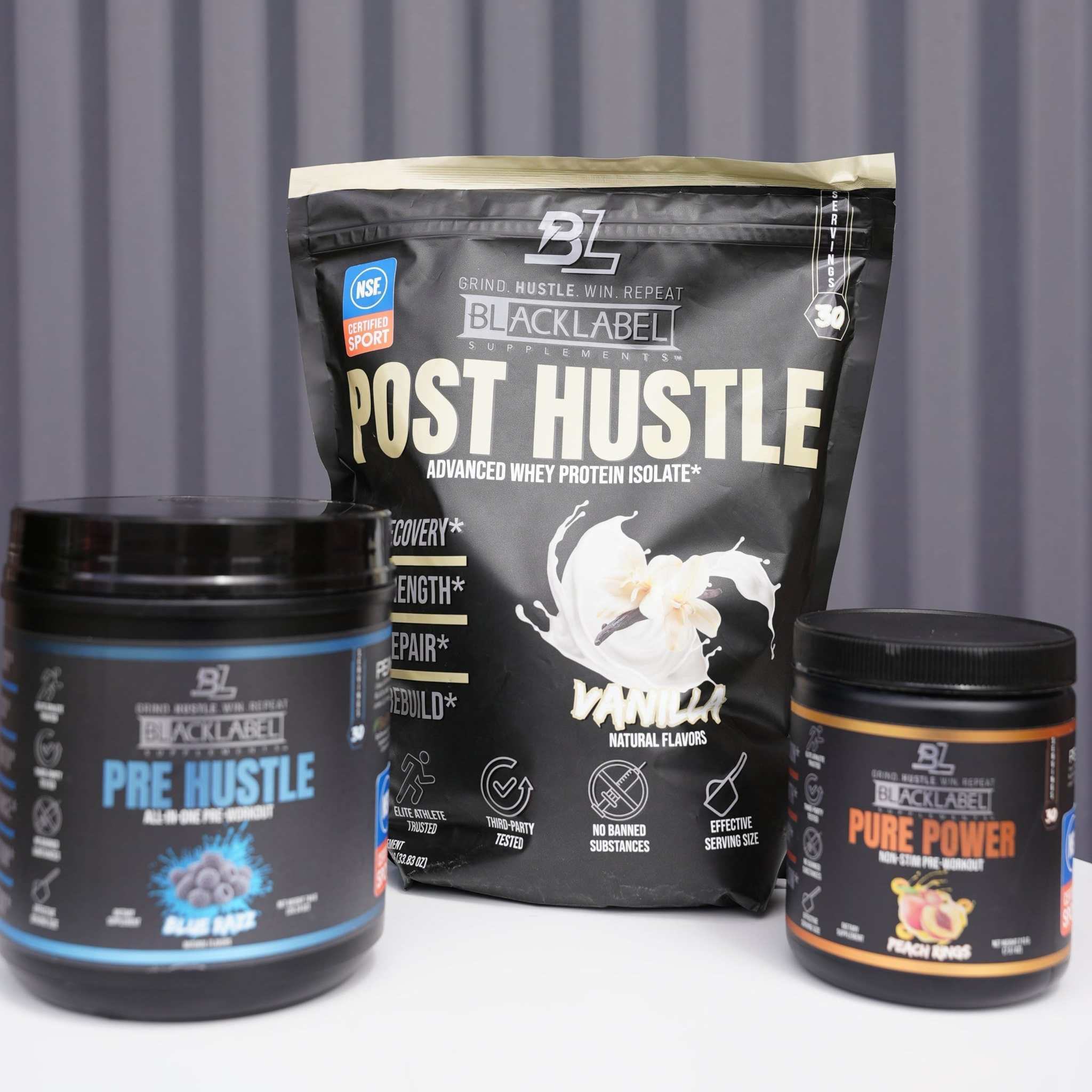 TRAINING STACK with black Pre Hustle and Pure Power tubs beside a black Post Hustle protein pouch