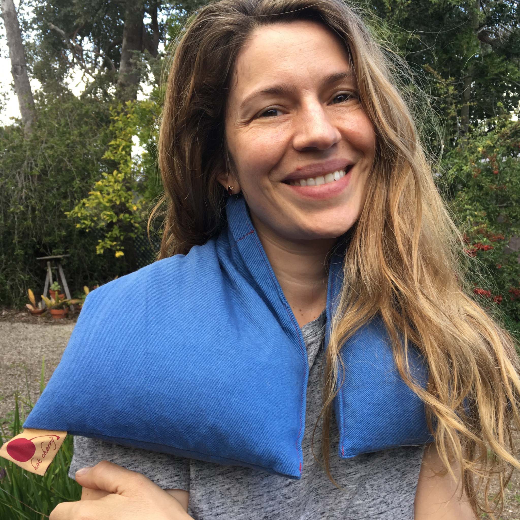 Triple Square Pillow in blue cotton denim, draped around the shoulders as a long, soft heat wrap