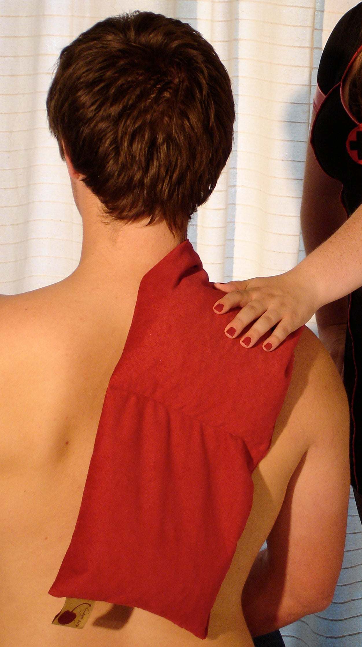 Triple Square pillow in red plush fabric draped over a person's shoulder, with a long rectangular shape and soft surface