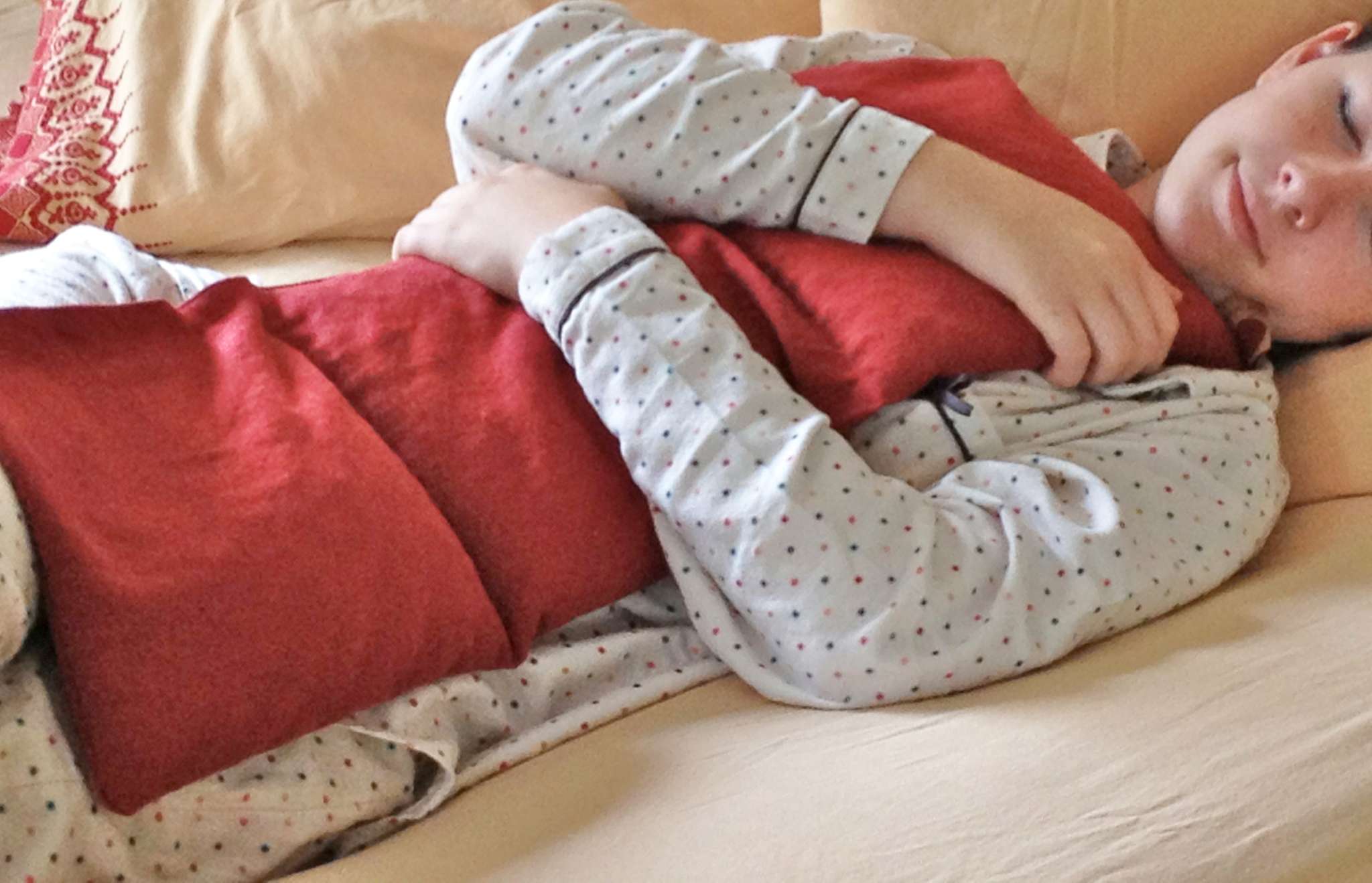 Triple Square Pillow in red fabric with a soft, plush surface and three joined square sections, held close by a child
