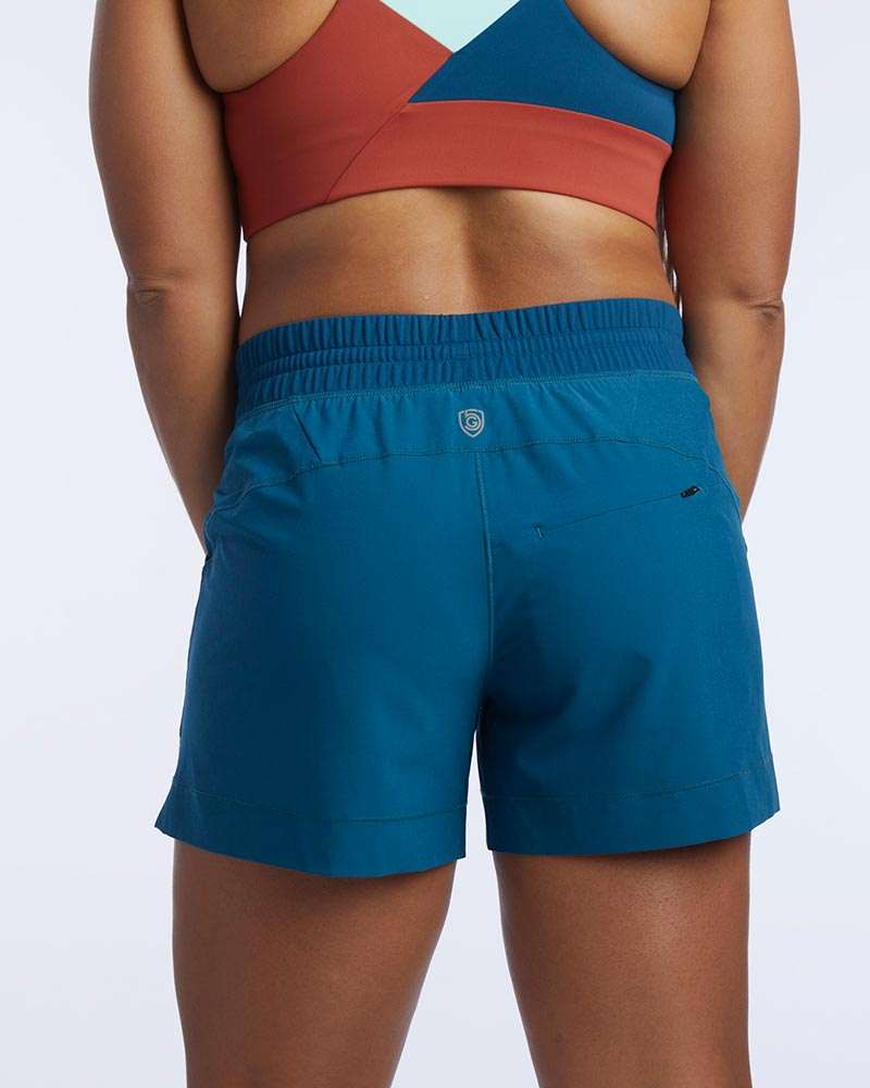 Triple V Womens Athletic Shorts in solid teal blue fabric with an elastic waistband and a small rear zip pocket