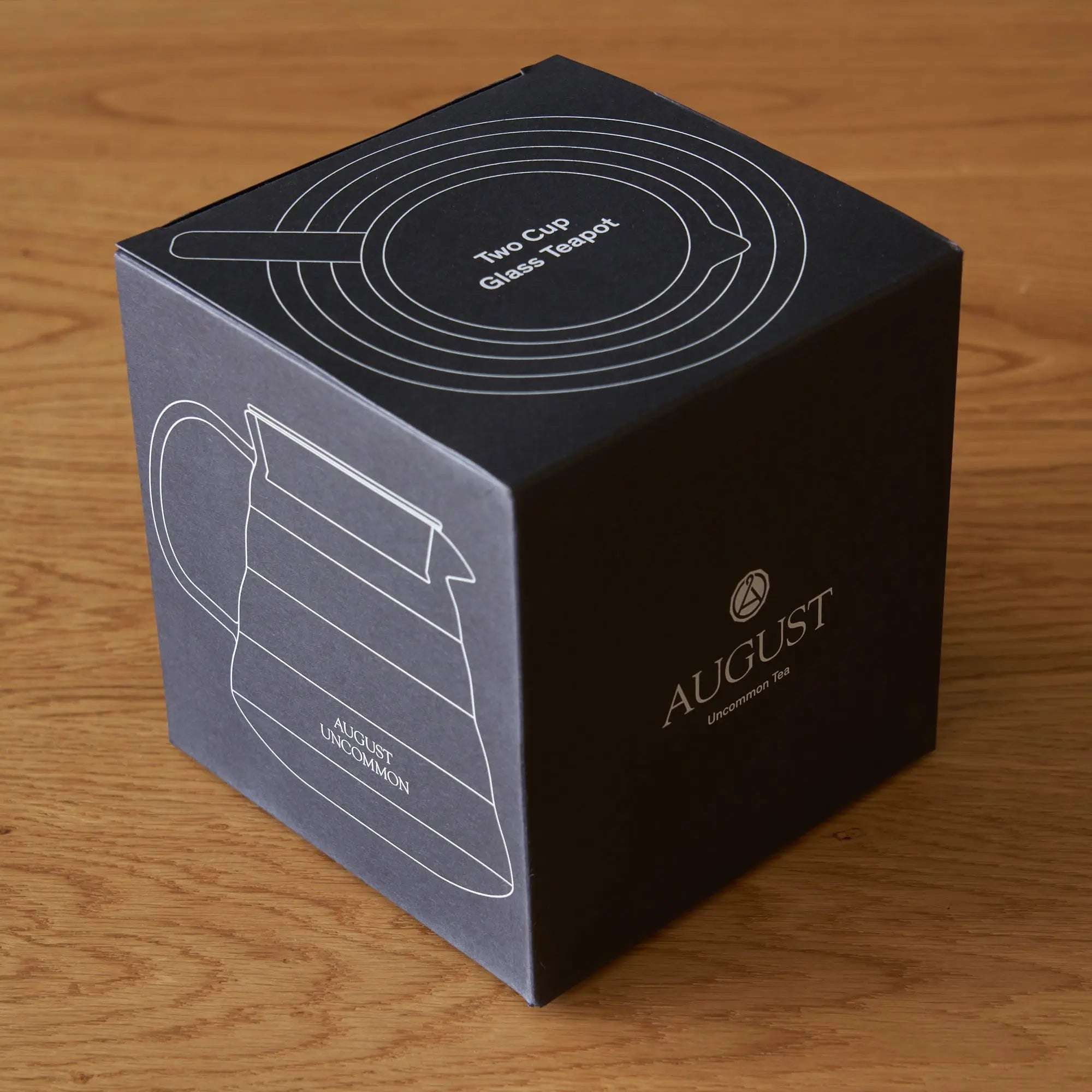 Two Cup Glass Teapot packaging in black with white teapot line art and circular lid design