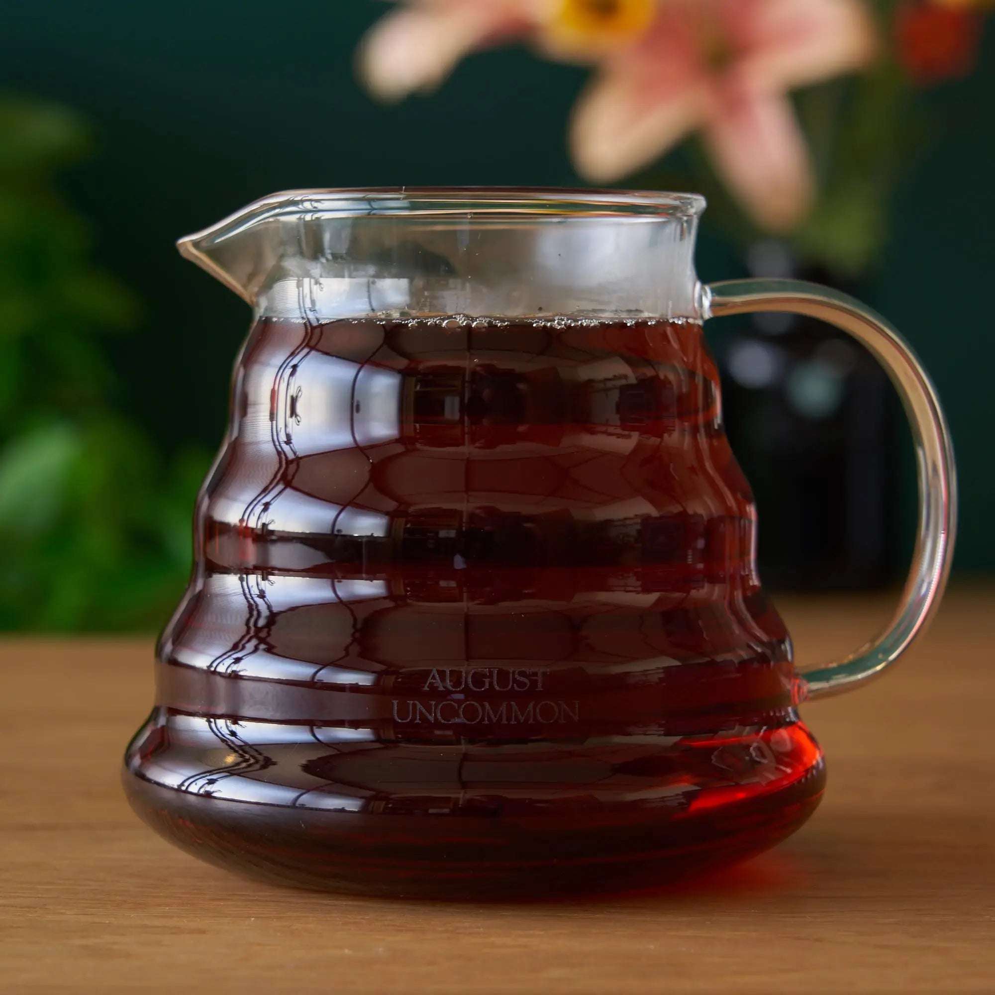 Two Cup Glass Teapot in clear heatproof glass with dark amber tea, curved handle, spout, and ridged body