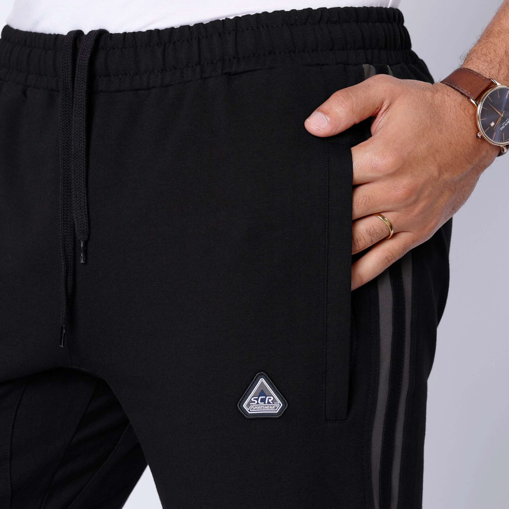 Ultimate Flex Athletic Sweatpants in black with a gathered drawstring waist, side pocket and small triangular logo