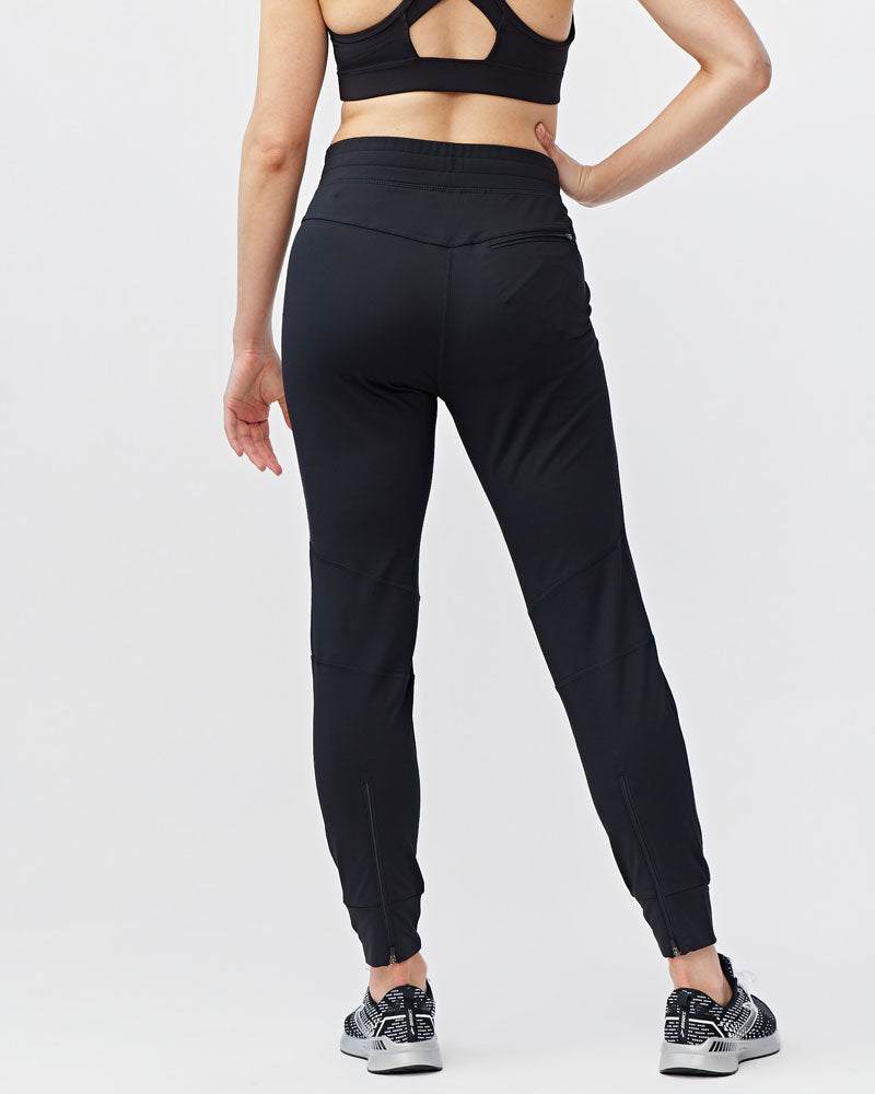 Valia Women's Black Jogger Pants in smooth black fabric, slim athletic fit with tapered legs and ankle cuffs