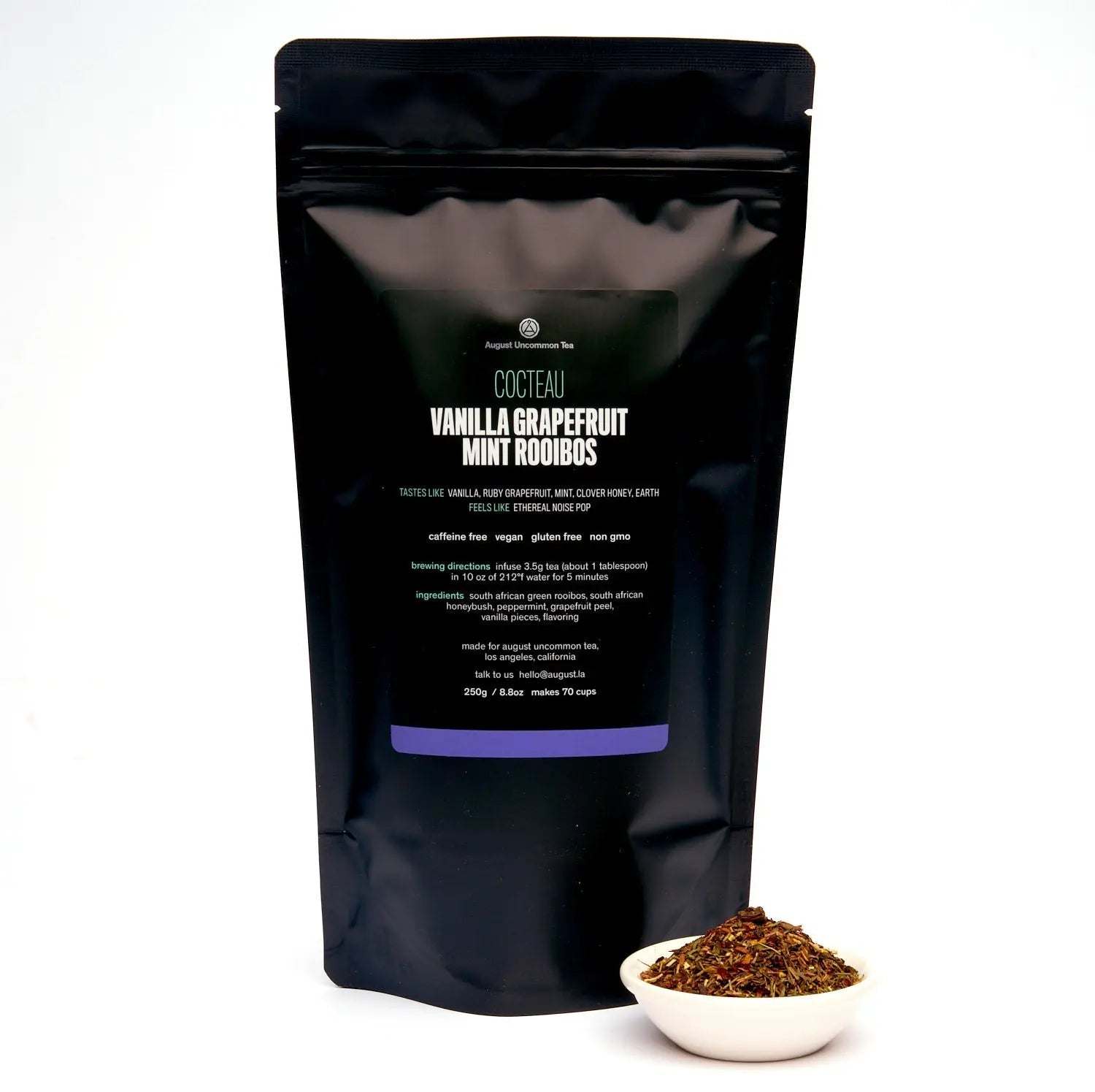 Vanilla Grapefruit Mint rooibos tea in a black resealable pouch with a small bowl of loose reddish-brown tea leaves