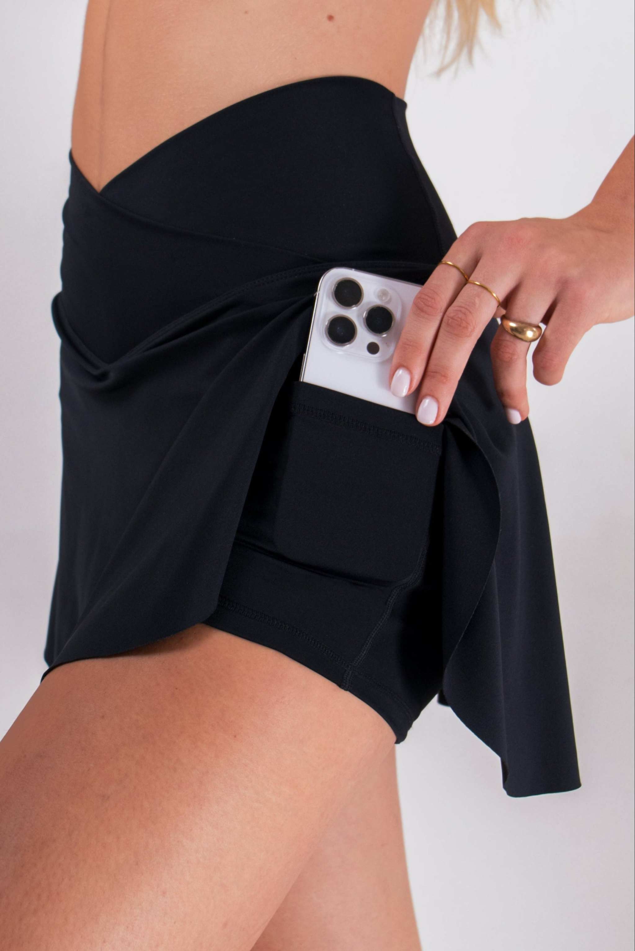 Women's Athletic Skort in black stretch fabric with a criss-cross waistband, built-in shorts and a phone pocket