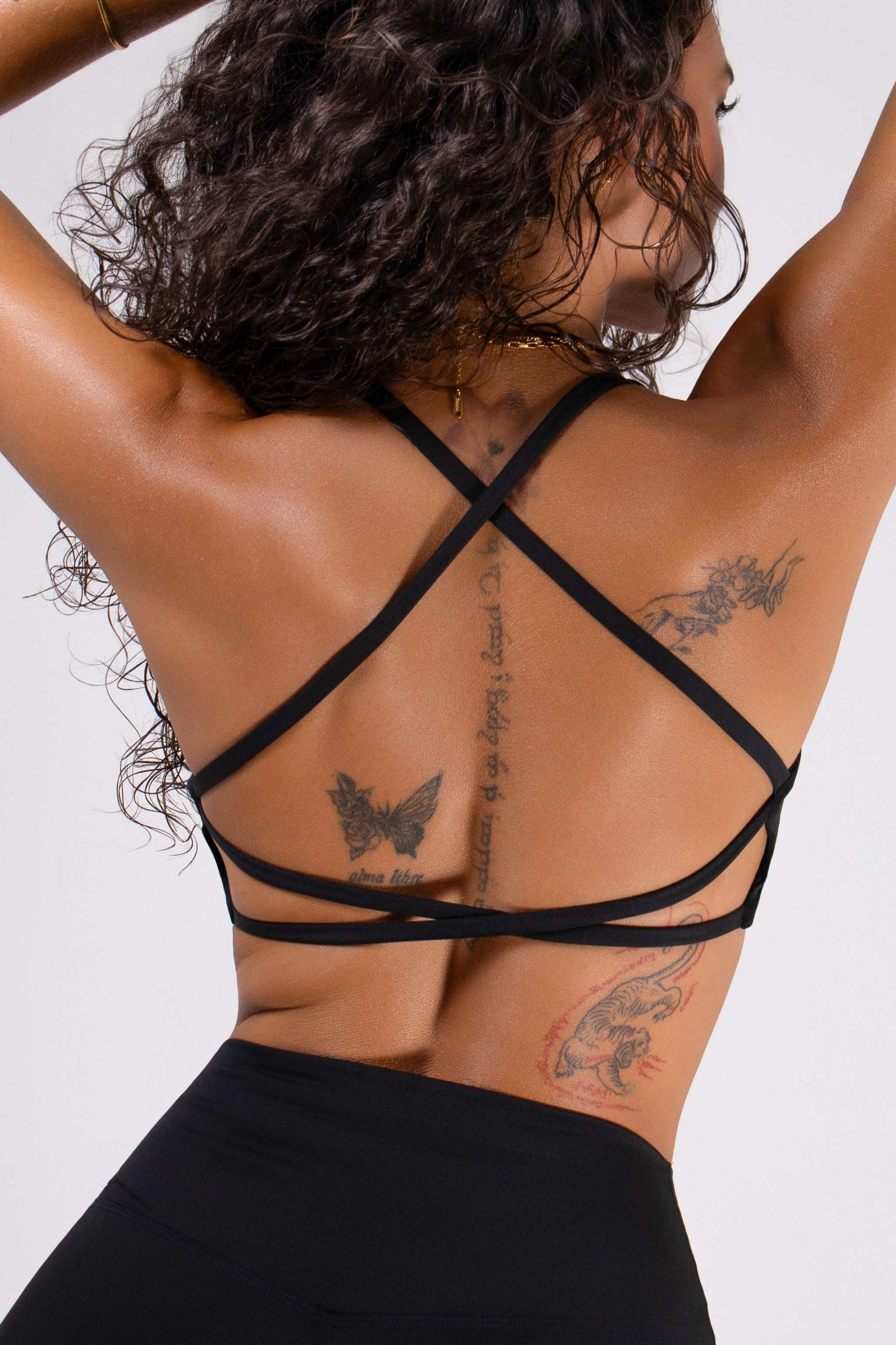 Women's Strappy Open-Back Sports Bra in black, with thin crossed back straps and a sleek, supportive band