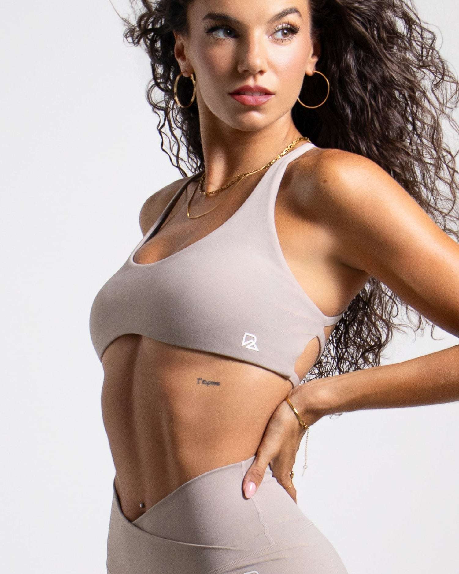 Women's Strappy Open-Back Sports Bra in taupe with a smooth matte finish, scoop neckline, and slim straps