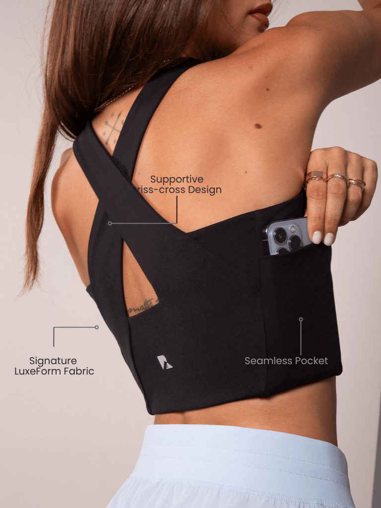 Women's Workout Tank Top in black stretch fabric with criss-cross back straps and a side pocket holding a phone
